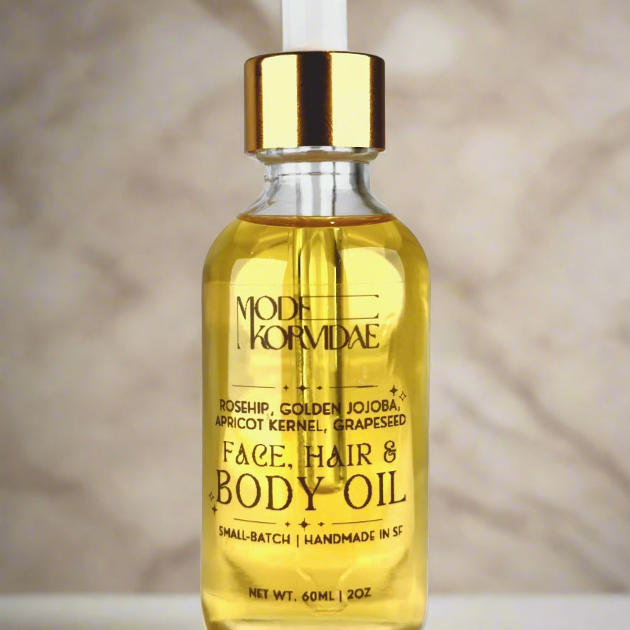 Clear glass of body oil in front of a white background