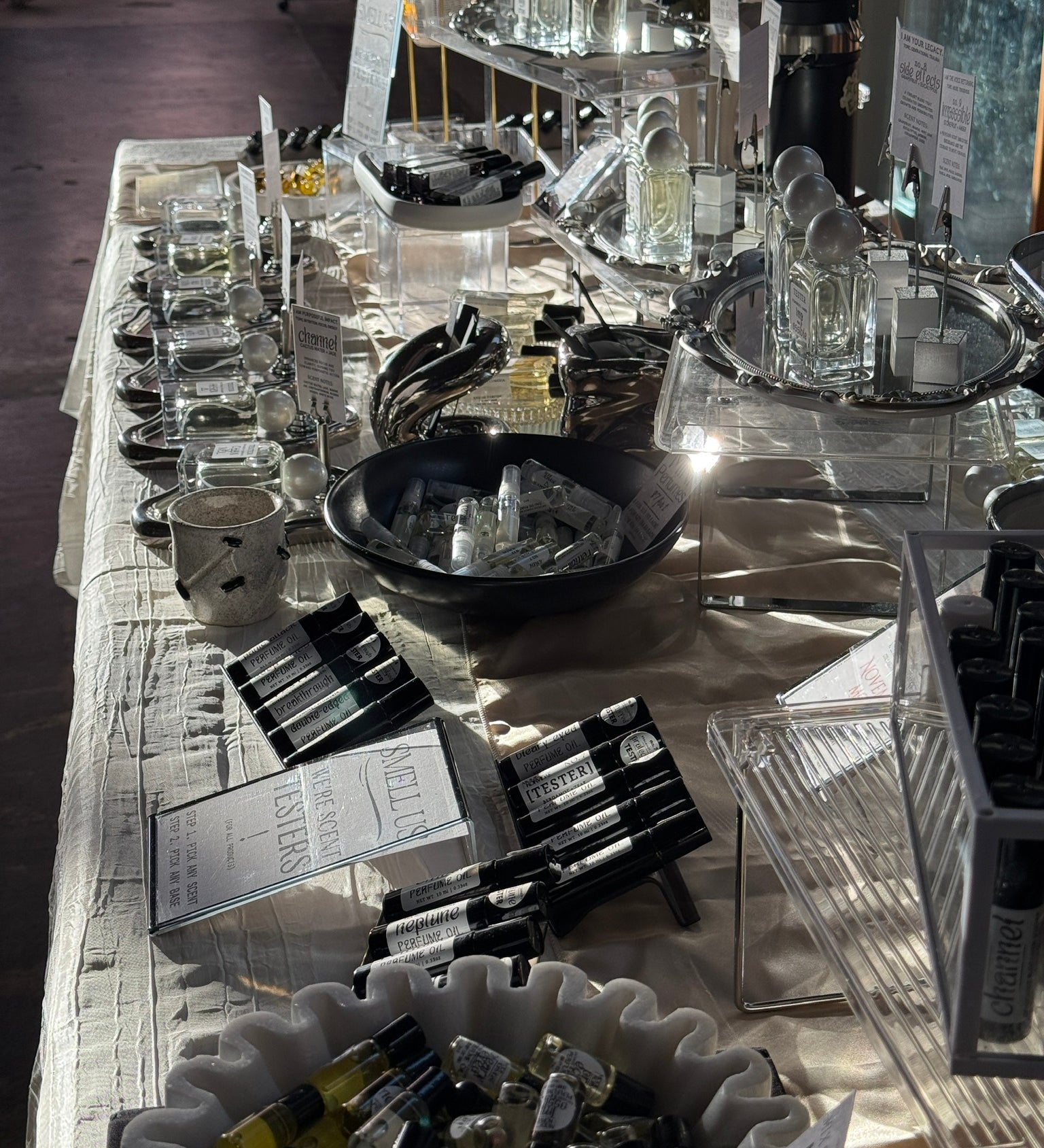 Display of perfumes and oils on a table with a dark background